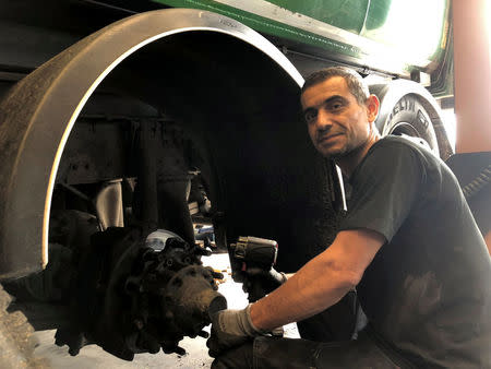 Muhsen Mousa, a 42-year-old Syrian refugee, who is employed as a mechanic at Scania's Swedish retail business works to repair a truck at the companyÕs workshop on the outskirts of Stockholm, Sweden July 6, 2018. Picture taken July 6, 2018. REUTERS/Esha Vaish