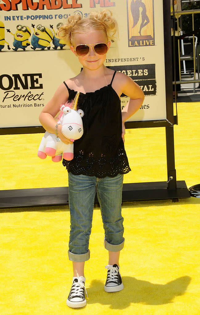 young Elsie wears a tank top, cuffed jeans, tiny Converse, and oversized sunglasses, and she carries a little version of the Unicorn plushie that Agnes has in the movie