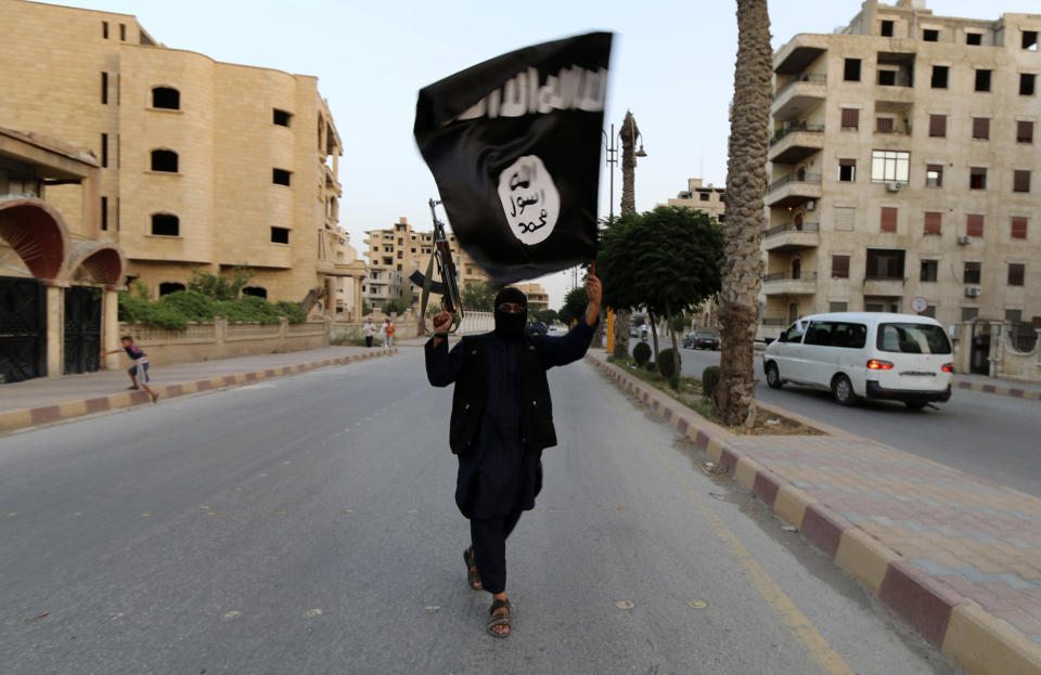 A member loyal to the Islamic State in Iraq and the Levant (ISIL) waves an ISIL flag in Raqqa June 29, 2014. The offshoot of al Qaeda which has captured swathes of territory in Iraq and Syria has declared itself an Islamic 