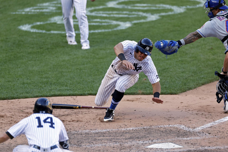 New York Yankees' Mike Tauchman scores the game winning run under a tag attempt by New York Mets catcher Wilson Ramos during the eighth inning of the first baseball game of a doubleheader, Sunday, Aug. 30, 2020, in New York. The Yankees won 8-7. (AP Photo/Adam Hunger)