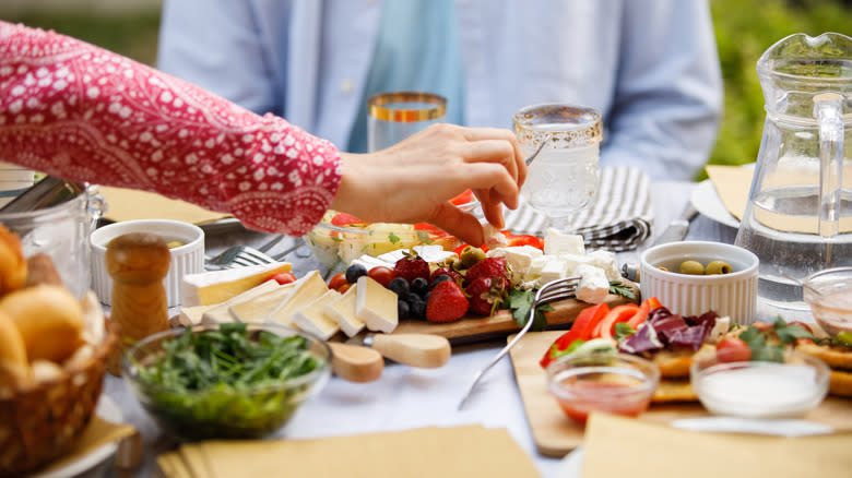 Woman grabs food from charcuterie board