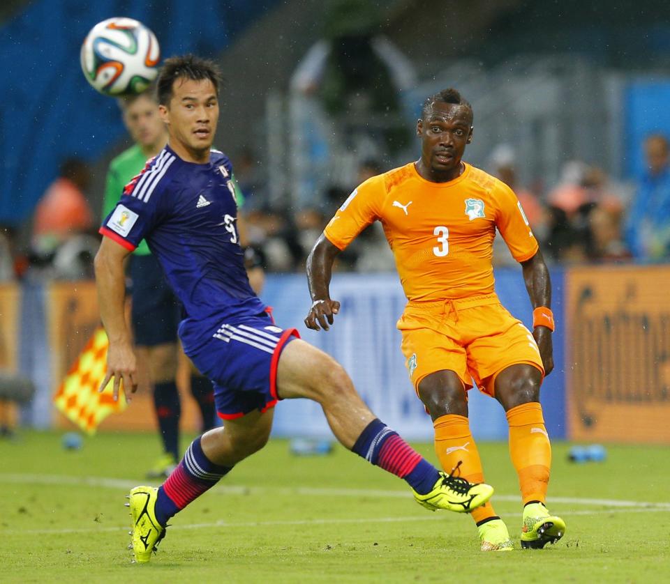 Japan's Yuto Nagatomo and Ivory Coast's Arthur Boka fight for the ball during their 2014 World Cup Group C soccer match at the Pernambuco arena in Recife, June 14, 2014. REUTERS/Brian Snyder