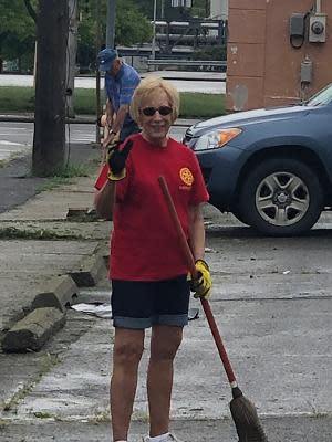 Darlene Leonard takes a break from cleaning up a parking lot. Cleanup projects are one of several projects done by the Endicott Rotary Club every year.