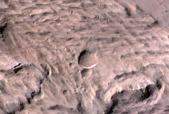 Scientists discovered a fresh crater carved into the surface of Mars by a March 2012 impact. This image was taken by the High Resolution Imaging Science Experiment (HiRISE) camera on NASA's Mars Reconnaissance Orbiter.