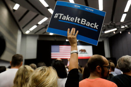 FILE PHOTO: A sign is raised as crowd waits for former U.S. President Barack Obama to speak at a political rally for California Democratic candidates in Anaheim, California, U.S., September 8, 2018. REUTERS/Mike Blake/File Photo