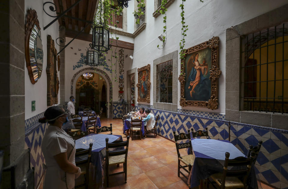 Customers eat in Mexico City's iconic "Cafe Tacuba" restaurant, while keeping their distance to help curb the spread of the new coronavirus, Wednesday, July 1, 2020. (AP Photo/Eduardo Verdugo)