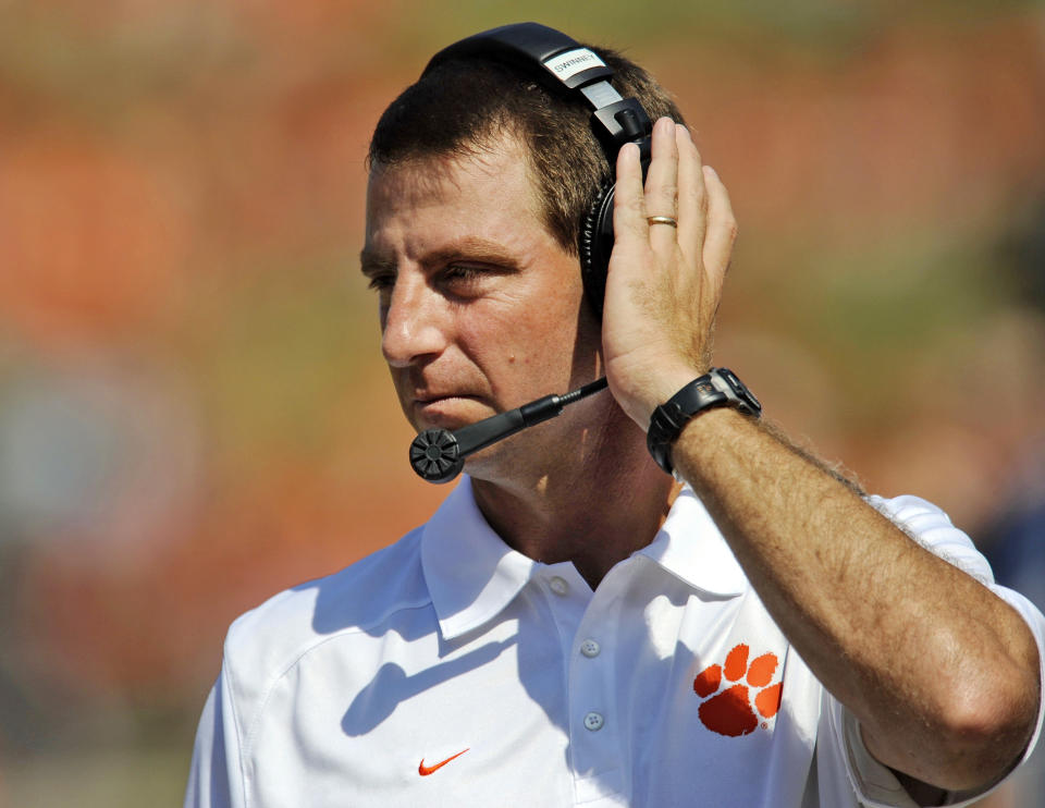 FILE - In this Sept. 7, 2013, file phot, Clemson coach Dabo Swinney talks on the headphones during the second half of an NCAA college football game Saturday against South Carolina State at Memorial Stadium in Clemson, S.C. Swinney received a new, eight-year contract and a raise that increased his total pay for next season to $3.15 million. (AP Photo/ Richard Shiro, File)