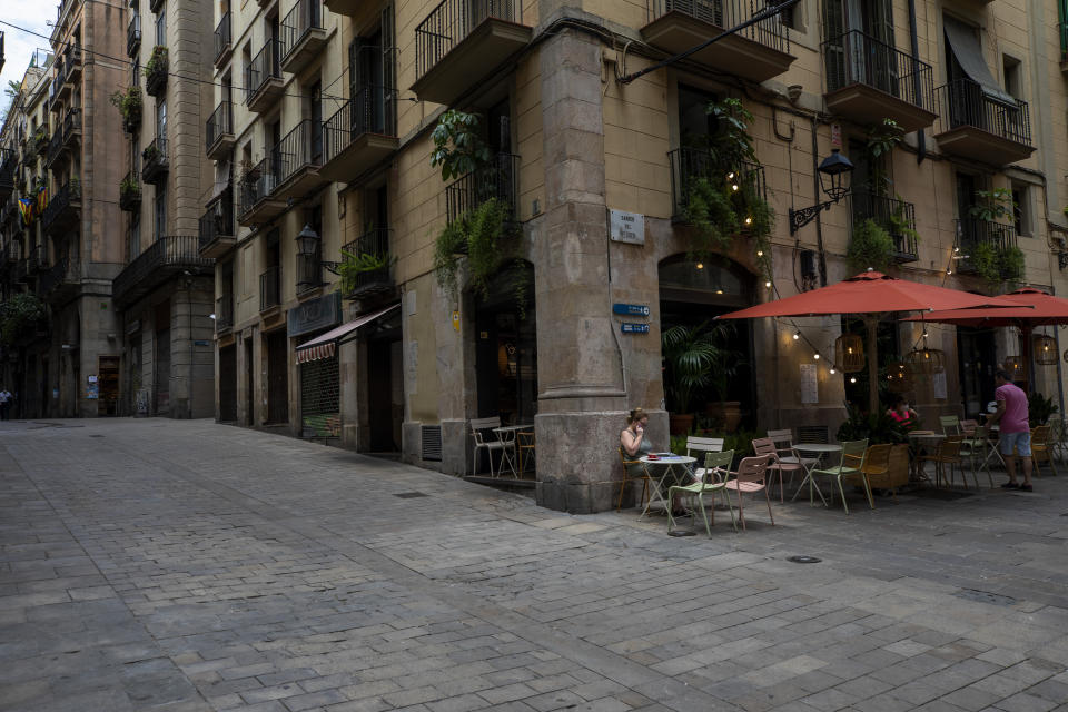 In this Monday, June 1, 2020 photo, local customers sit in a terrace bar in downtown Barcelona. Spain is waiting until July to reopen its border for foreign tourists. In the meantime, authorities are encouraging Spaniards to vacation inside at home. (AP Photo/Emilio Morenatti)