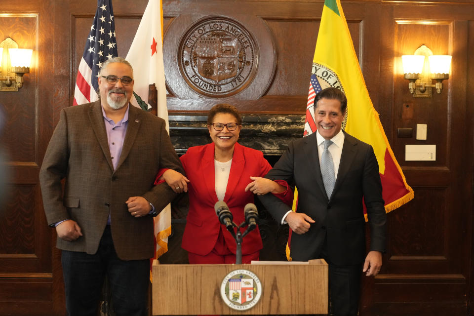 SEIU Local 99 Executive Director Max Arias, left, Los Angeles Mayor Karen Bass and District superintendent Alberto Carvalho lock in arms after announcing on a new contract together in Los Angeles City Hall Friday, March 24, 2023. The Los Angeles Unified School District and union leaders say they have reached a deal on a new contract for workers after a strike that shut down the nation's second-largest school system for three days. (AP Photo/Damian Dovarganes)