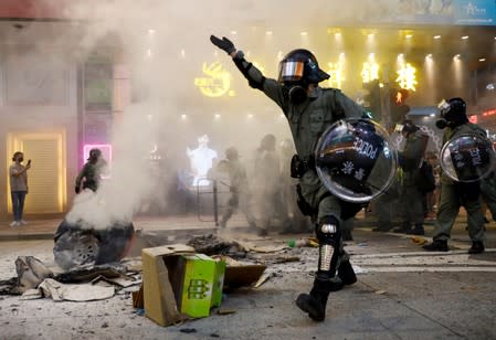 Riot police walk next to a street barricade during a demonstration in Mong Kok district in Hong Kong