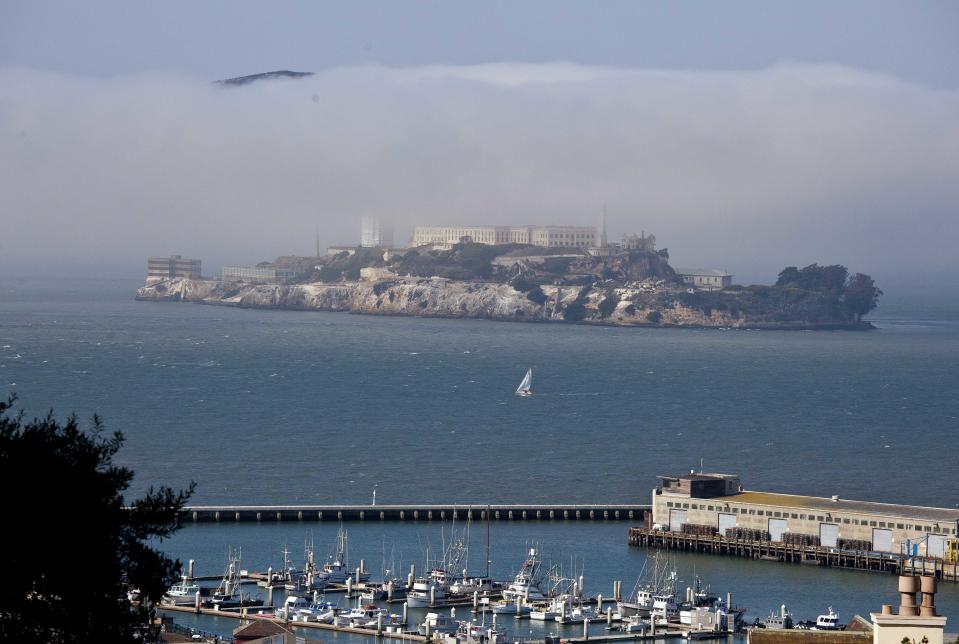 In this photo taken Thursday, Sept. 27, 2012, a sailboat makes its way past Alcatraz Island in San Francisco. San Francisco has a long history as a favorite site for filmmakers and the movie buffs who want to see the spots where their favorite scenes took place, from Fort Point under the Golden Gate Bridge where Jimmy Stewart saved Kim Novak in "Vertigo" to the steps of City Hall, where Sean Penn gave an impassioned speech in "Milk," to Alcatraz, stage for Clint Eastwood and many others. (AP Photo/Eric Risberg)