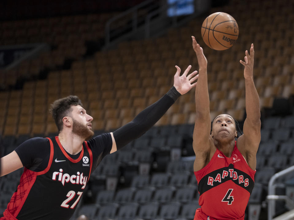 Toronto Raptors forward Scottie Barnes (4) battles with Portland Trail Blazers center Jusuf Nurkic (27) for a rebound during first-half NBA basketball game action in Toronto, Sunday Jan. 23, 2022. (Frank Gunn/The Canadian Press via AP)