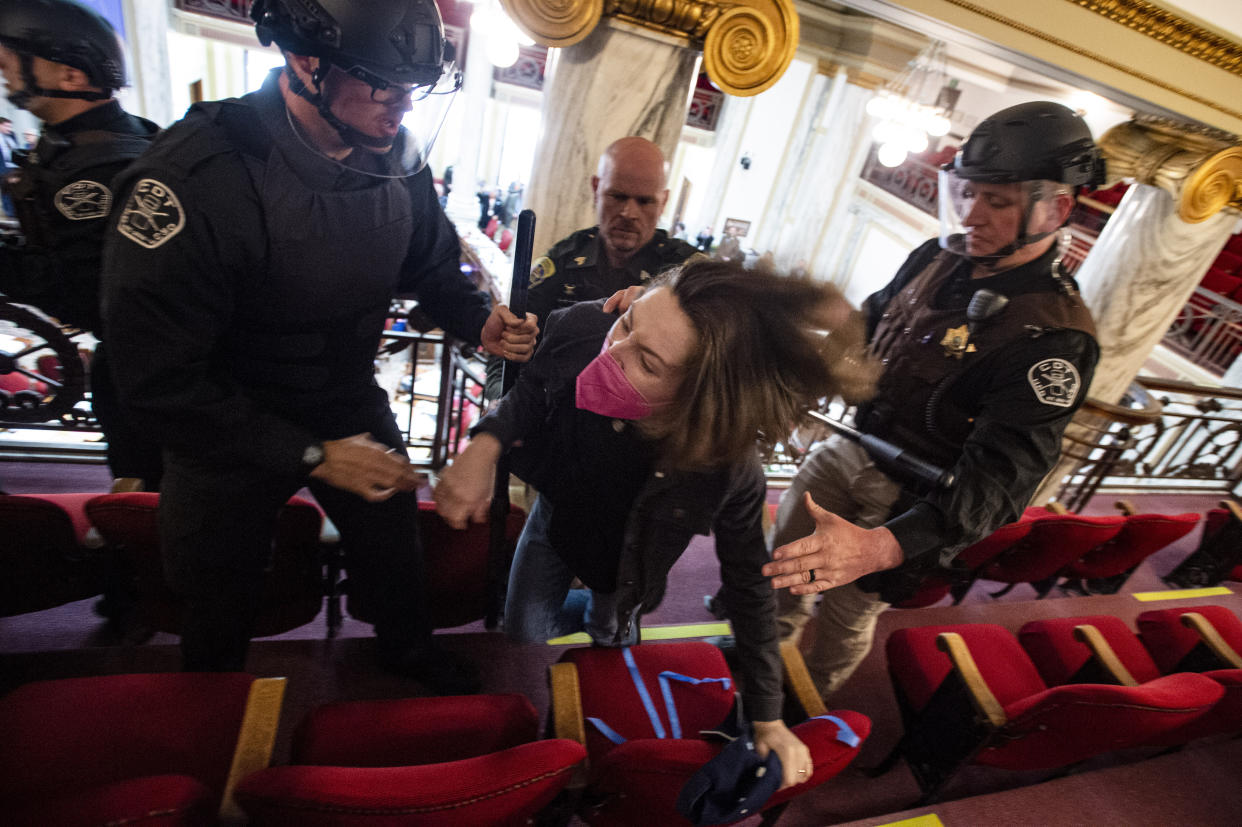 Law enforcement forcibly clear the Montana House of Representatives gallery during a protest after the Speaker of the House refused again to acknowledge Rep. Zooey Zephyr, D-Missoula, on Monday, April 24, 2023, in the State Capitol in Helena, Mont. Republican legislative leaders in Montana persisted in forbidding the Democratic transgender lawmaker from participating in debate for a second week as her supporters brought the House session to a halt Monday, chanting "Let her speak!" from the gallery before they were escorted out. (Thom Bridge/Independent Record via AP)