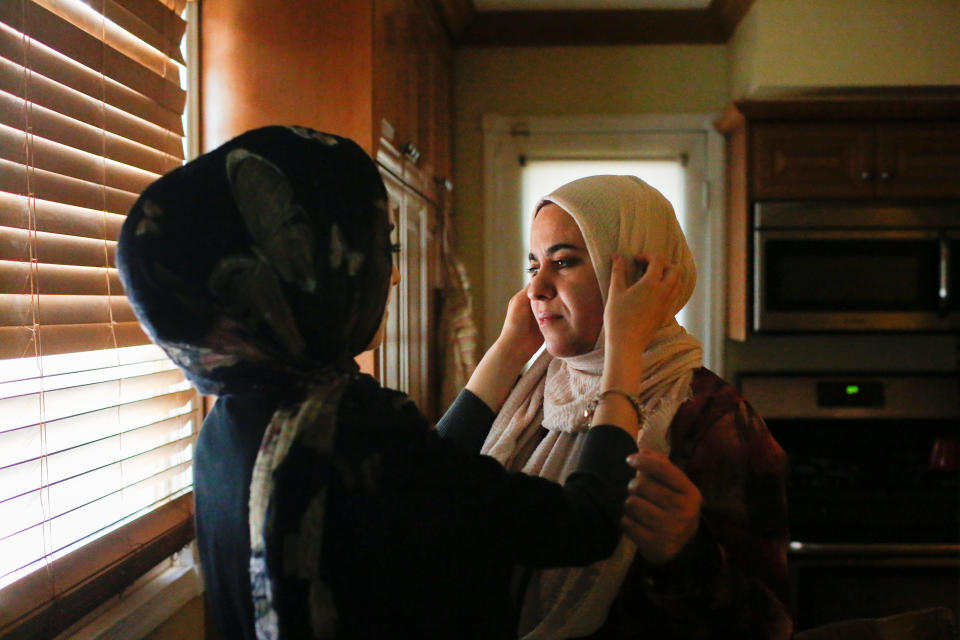 Nevien Shehadeh, 19, a Palestinian American, adjusts the head scarf of her mother Wisal before they depart their home to take part in prayers and celebrate the Muslim holiday Eid al-Fitr in Staten Island, New York, U.S., June 25, 2017.&nbsp;