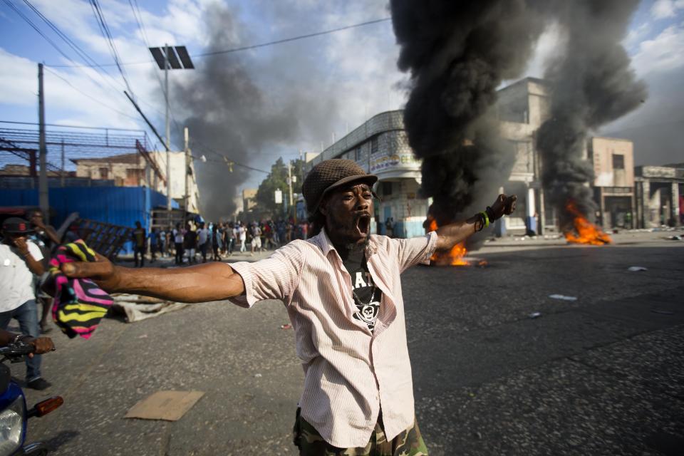 Un manifestante corea consignas contra el gobierno durante una protesta para exigir saber el uso que las autoridades le dieron a los fondos de Petrocaribe, en Puerto Príncipe, Haití, el domingo 18 de noviembre de 2018. (AP Foto/Dieu Nalio Chery)