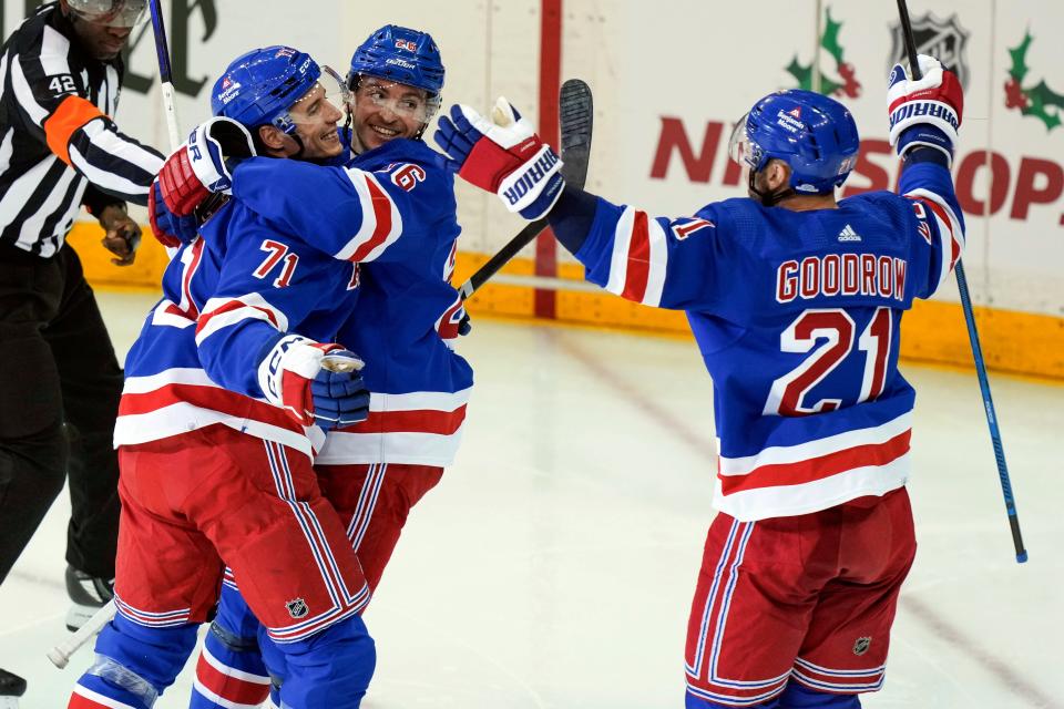 New York Rangers Tyler Pitlick (71) celebrates with Jimmy Vesey (26) and Barclay Goodrow (21) following his goal during the third period an NHL hockey game against the Boston Bruins, Saturday, Nov. 25, 2023, in New York.