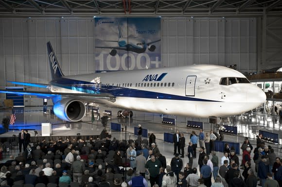 A Boeing 767 in a hanger surrounded by people.