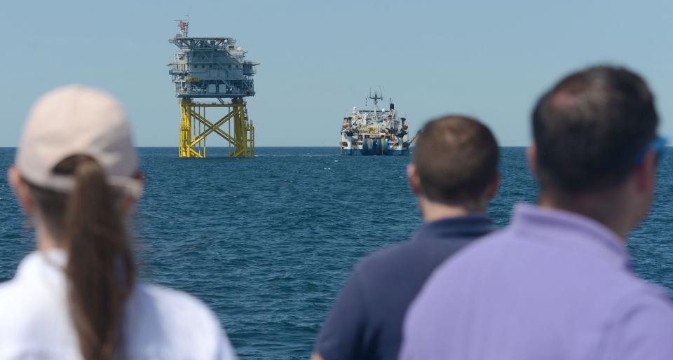 A newly installed substation, at left, and a cable-laying ship working alongside catch the attention of guests on Wednesday during a day-long visit to the Vineyard Wind offshore wind farm south of Martha's Vineyard.