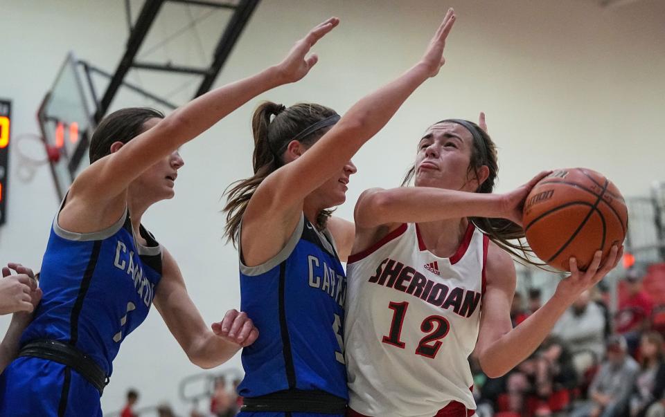 Sheridan Blackhawks Kenzie Garner (12) reaches for a lay-up against Carroll Cougars Madison Wagner (5) on Thursday, Nov. 9, 2023, during the game at Sheridan High School in Sheridan. The Carroll Cougars defeated the Sheridan Blackhawks, 48-44.