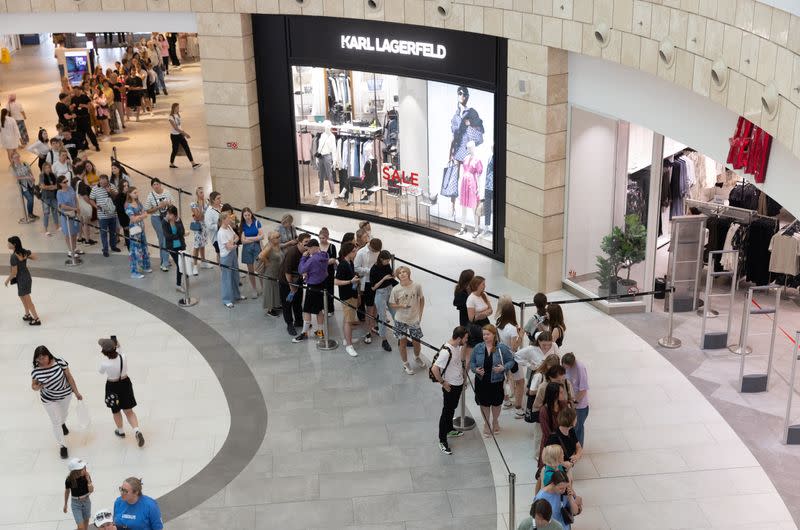 People line up to enter an H&M store in Moscow