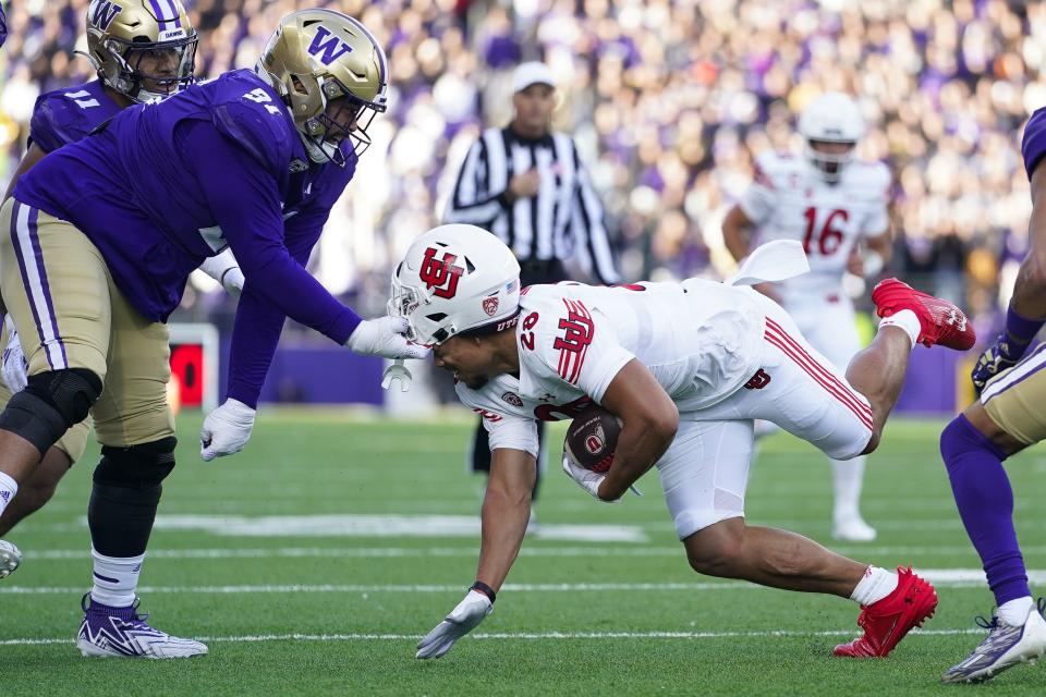 Washington defensive lineman Tuli Letuligasenoa (91) is called for a penalty as he pulls off the helmet of Utah running back Sione Vaki (28) during the first half of an NCAA college football game Saturday, Nov. 11, 2023, in Seattle. | Lindsey Wasson, Associated Press