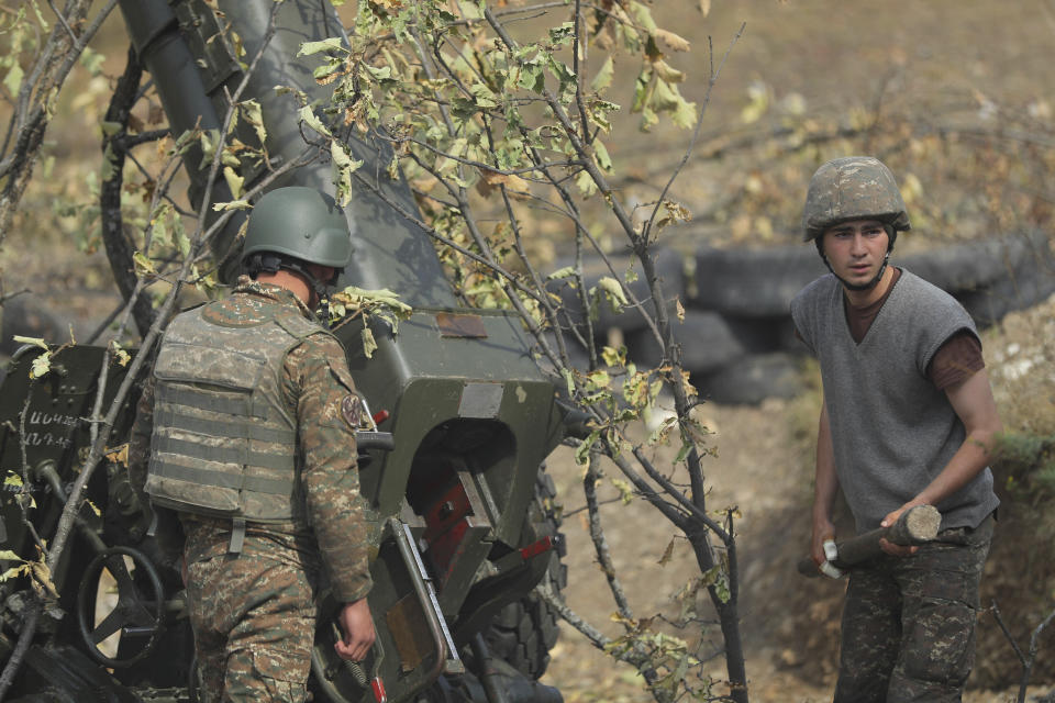 Ethnic Armenian soldiers fire an artillery piece at a fighting position on the front line, during a military conflict against Azerbaijan's armed forces in the separatist region of Nagorno-Karabakh, Wednesday, Oct. 21, 2020. Armenia's prime minister has urged citizens to sign up as military volunteers to help defend the country amid the conflict with Azerbaijan over the disputed territory of Nagorno-Karabakh as intense fighting has raged for a fourth week with no sign of abating. (Sipan Gyulumyan, Armenian Defense Ministry Press office/ PAN Photo via AP)