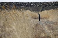 A man offers prayers at the site where a house of his missing colleague once stood, in Ishinomaki, Miyagi prefecture, Japan Saturday, March 11, 2017. On Saturday, Japan is marking the anniversary of the 2011 massive earthquake and tsunami that struck the nation. (Hiroki Yamauchi/Kyodo News via AP)