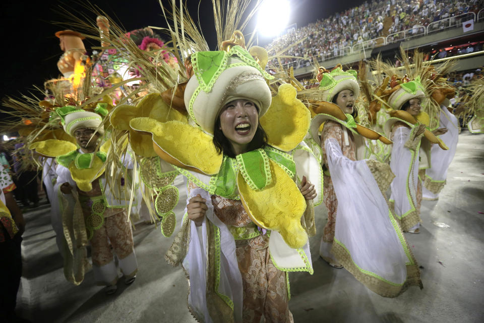 Japanese performers from the Mangueira samba school, parade during carnival celebrations at the Sambadrome in Rio de Janeiro, Brazil, Tuesday, Feb. 12, 2013. While non-Brazilians have long shelled out hundreds of dollars for the right to dress up in over-the-top costumes and boogie in Rio's samba school parades, which wrapped up Monday in an all-night extravaganza, few in the so-called "alas dos gringos," or “foreigners' wings,” know how to dance the samba well, bopping along goofily in the parades and waving at the crowds of spectators. (AP Photo/Silvia Izquierdo)