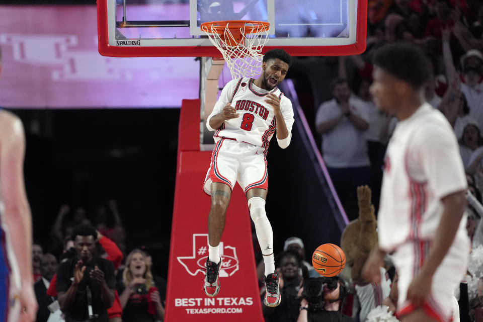 Houston's Mylik Wilson (8) screams after dunking the ball against Kansas during the first half of an NCAA college basketball game Saturday, March 9, 2024, in Houston. (AP Photo/David J. Phillip)