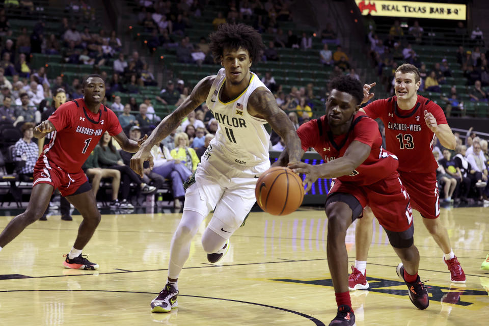 Baylor forward Jalen Bridges (11) and Gardner-Webb guard Caleb Robinson, front right, reach for the ball in the first half of an NCAA college basketball game, Sunday, Nov. 12, 2023, in Waco, Texas. (AP Photo/Jerry Larson)