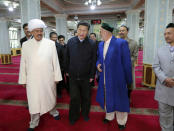 In this Wednesday, April 30, 2014 photo released by China's Xinhua News Agency, Chinese President Xi Jinping, front center, visits a mosque in Urumqi, capital of northwest China's Xinjiang Uygur Autonomous Region. Xi had an inspection tour in Xinjiang from April 27 to April 30. (AP Photo/Xinhua, Lan Hongguang) NO SALES