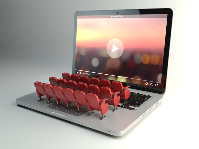 Miniature movie seats sitting on a laptop's keyboard