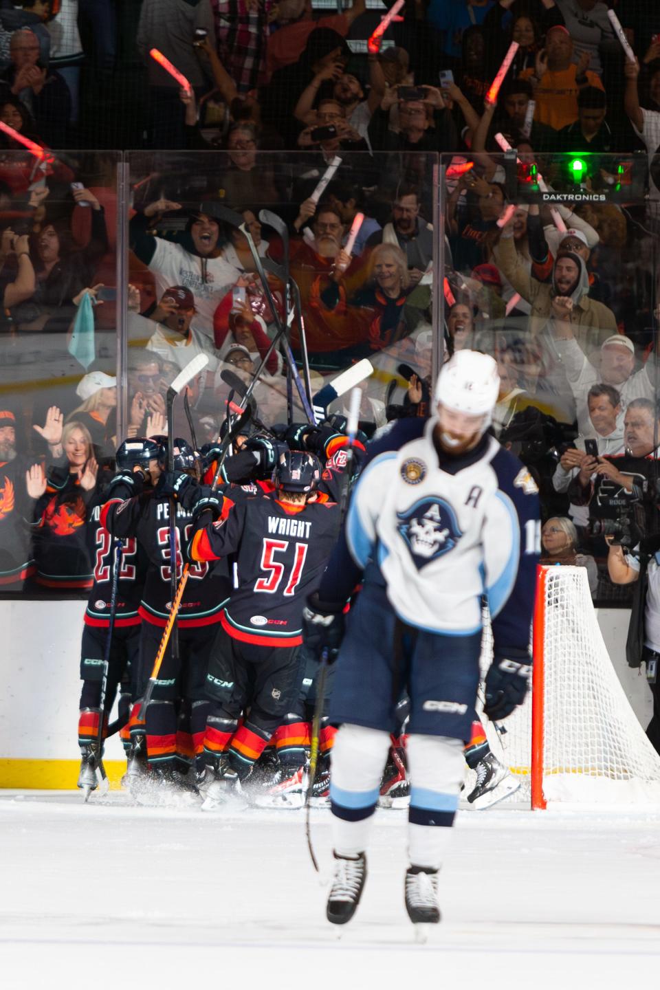 The Coachella Valley Firebirds team erupts in celebration after clinching the Western Conference Championship title, solidifying their place in the Calder Cup Finals. The players join together in a display of pure elation, reflecting the culmination of their hard work and determination throughout the season.