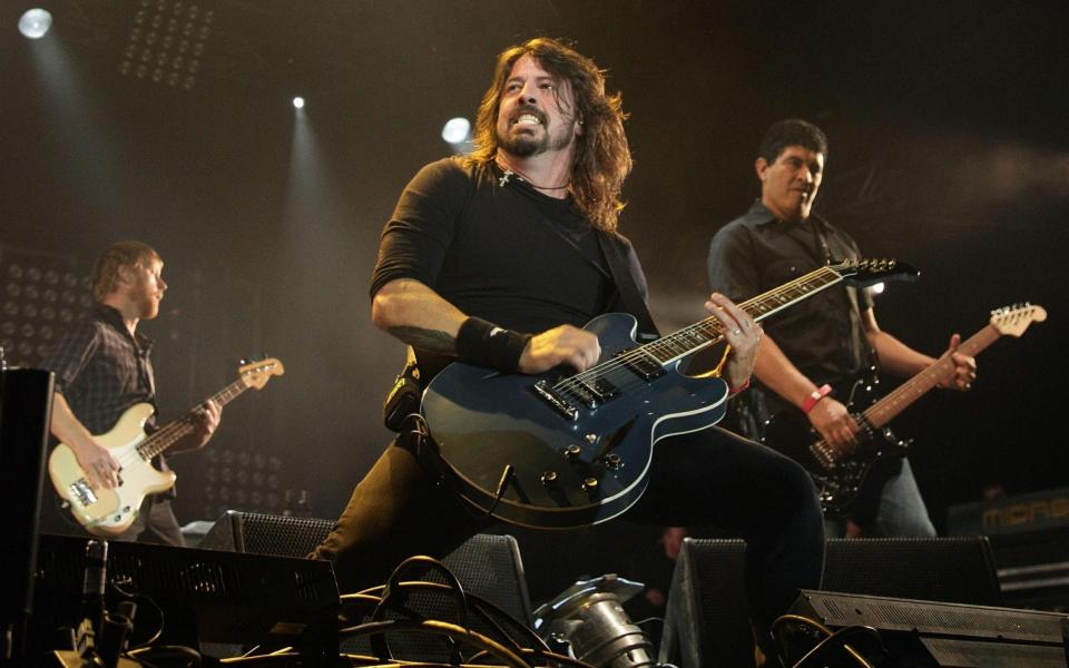Dave Grohl (centre) of the Foo Fighters, who were forced to pull out of their slot - Yui Mok/PA