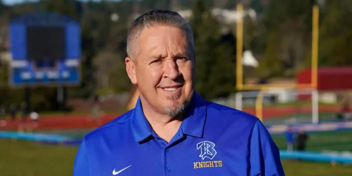 Joe Kennedy, a former assistant football coach at Bremerton High School in Bremerton, Wash., poses for a photo March 9, 2022, at the school's football field.