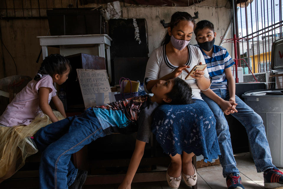 Magali, 35, and her sons wait outside Huellas de Pan Association, a a nonprofit working on food security, before a healthy-nutrition workshop in one of the poorest neighborhoods in Cancún.<span class="copyright">Claudia Guadarrama—Magnum Foundation for TIME</span>