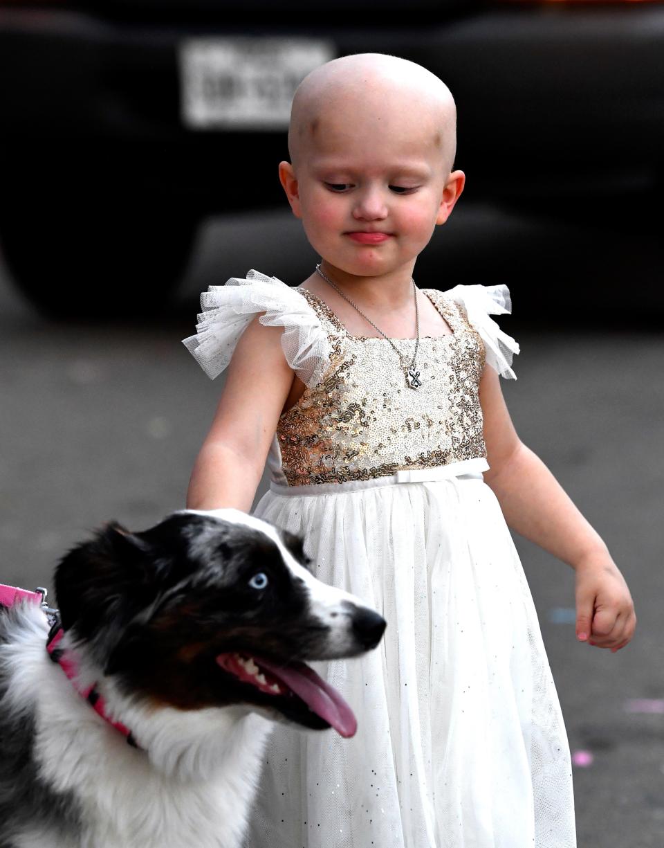 The parade outside her home pauses as Sienna pets a friendly dog Tuesday.