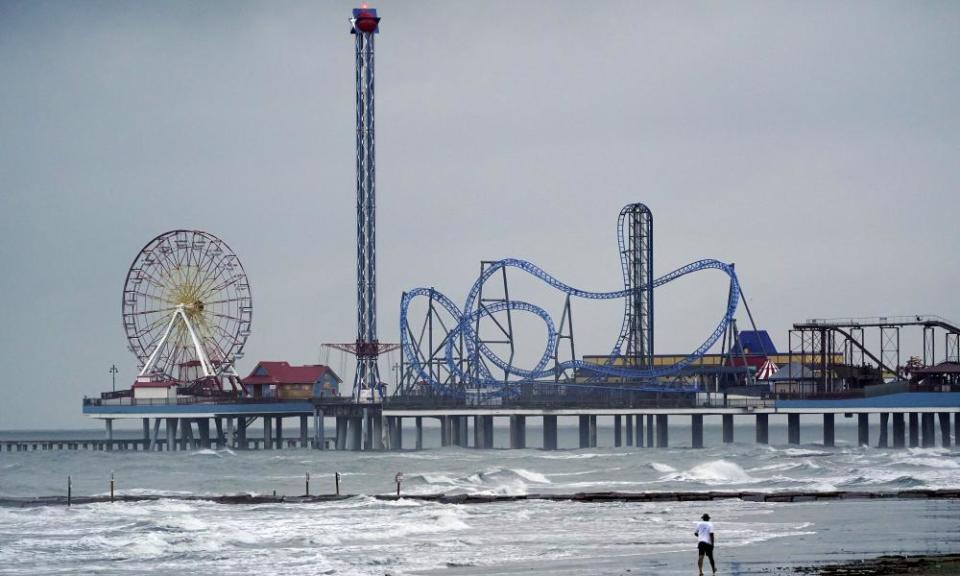 A man walks along the beach Wednesday in Galveston, Texas, as Hurricane Laura moves toward the gulf coast.