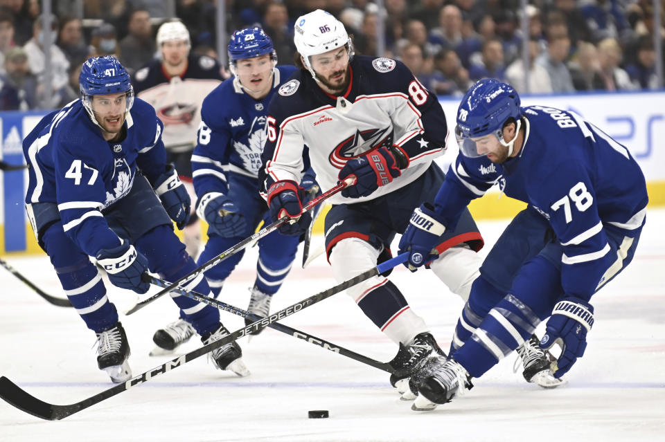 Toronto Maple Leafs defenceman T. J. Brodie (78) controls the puck against Columbus Blue Jackets right winger Kirill Marchenko (86) during the first period of an NHL hockey game Saturday, Feb. 11, 2023, in Toronto. (Jon Blacker/The Canadian Press via AP)