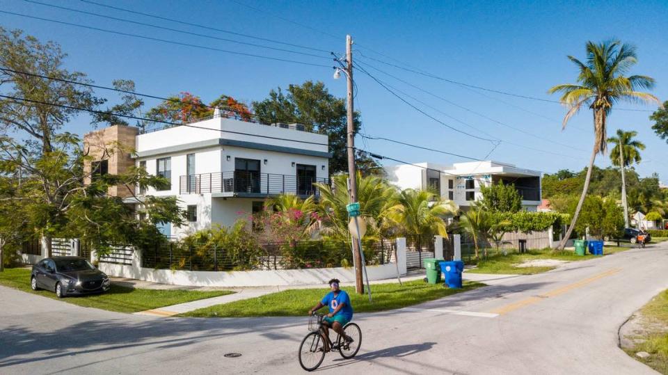 A resident of Miami’s historically Black West Coconut Grove cycles down what was until recently a street of modest working-class homes at the intersection of Elizabeth Street and Frow Avenue on Thursday, June 16, 2022. The mostly low-income West Grove community is disappearing amid the construction of multimillion-dollar “white cubes” that are sold to mostly white affluent buyers.