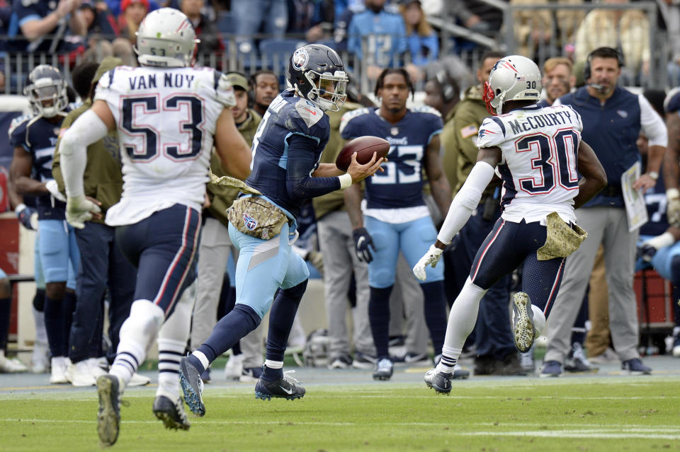 Tennessee Titans quarterback Marcus Mariota (8) catches a pass between New England Patriots defenders Kyle Van Noy (53) and Jason McCourty (30) in the second half of an NFL football game Sunday, Nov. 11, 2018, in Nashville, Tenn. (AP Photo/Mark Zaleski)