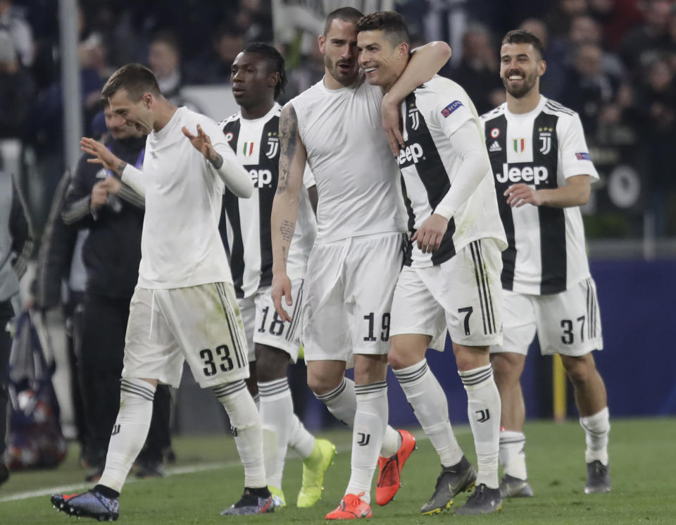 Juventus' Leonardo Bonucci, centre left and Cristiano Ronaldo hug at the end of the Champions League round of 16, 2nd leg, soccer match between Juventus and Atletico Madrid at the Allianz stadium in Turin, Italy, Tuesday, March 12, 2019. (AP Photo/Luca Bruno)