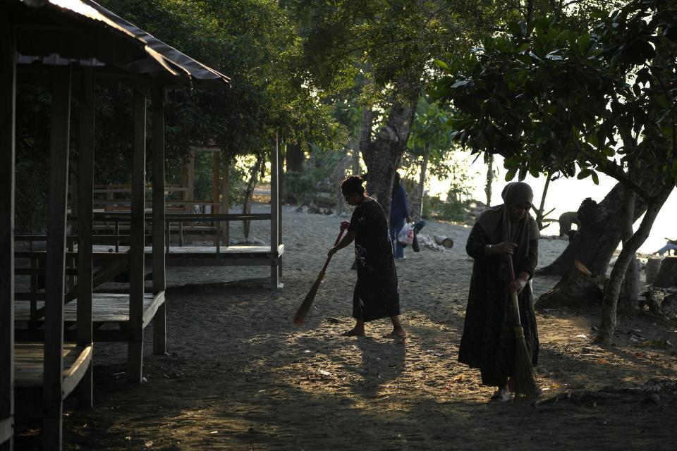 Food stall owners clean the beach to prepare for the arrival of tourists where maleos are known to lay their eggs, in Mamuju, West Sulawesi, Indonesia, Saturday, Oct. 28, 2023. With their habitat dwindling and nesting grounds facing encroachment from human activities, the journey of a maleo pair for egg laying grows ever more precarious and uncertain. Maleo populations have declined by more than 80% since 1980, an expert said. (AP Photo/Dita Alangkara)