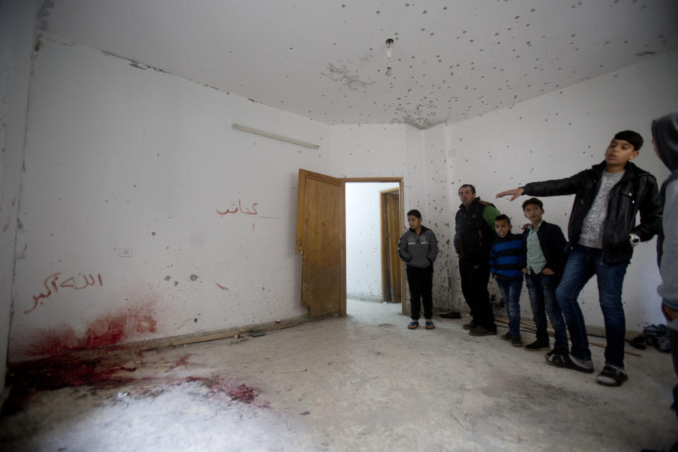 Palestinians look at a damage after an Israeli raid killed Ashraf Naalweh during an arrest raid in the Asker refugee camp near the West Bank city of Nablus, Thursday, Dec. 13, 2018. Israel accuses Naalweh of shooting to death two Israelis and wounding another at an attack on a West Bank industrial zone in October. He fled the scene and Israeli forces have been searching for him since. (AP Photo/Majdi Mohammed)