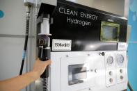 An employee fuels hydrogen to a Hyundai Motor's Nexo hydrogen car at a hydrogen station in Seoul