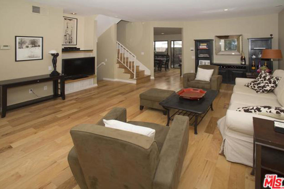 <p>The residence features wide-plank hardwood floors throughout. The living room also has a fireplace and large windows. (Trulia.com) </p>