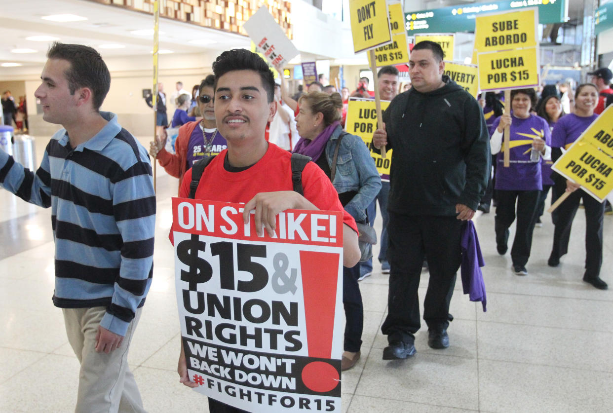 Marching through one of the terminals, some 200 low-wage workers take part in a protest named 