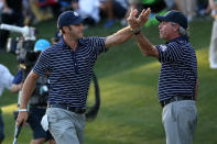 Dustin Johnson of the USA (L) celebrates his birdie putt on the 17th green with Fred Couples during day two of the Afternoon Four-Ball Matches for The 39th Ryder Cup at Medinah Country Club on September 29, 2012 in Medinah, Illinois. (Photo by Ross Kinnaird/Getty Images)