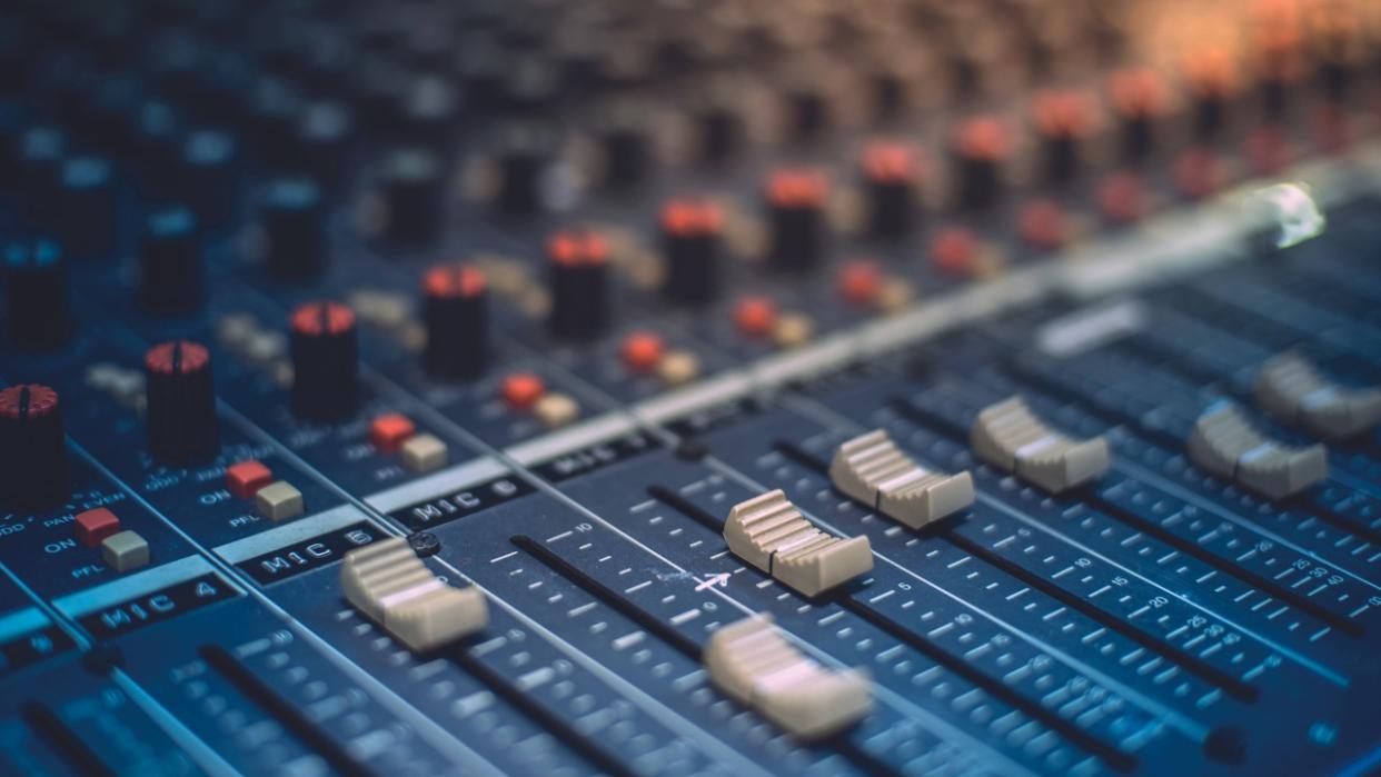  Close up of the sliders on a mixing desk. 