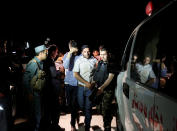 <p>Afghan men walk towards an ambulance after they were rescued from the site of an attack at American University of Afghanistan in Kabul on Aug. 24, 2016. (REUTERS/Mohammad Ismail) </p>